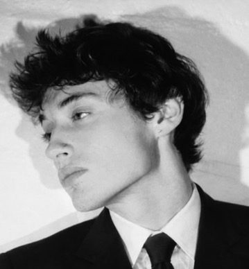 Black-and-white portrait of Nick Benak in a suit and tie